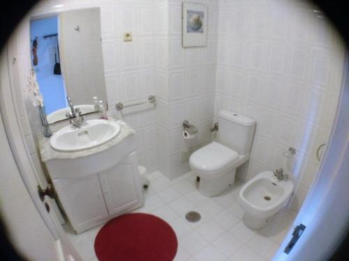 een witte badkamer met een toilet en een wastafel bij Walk Aveiro in Aveiro