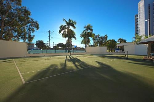 a grassy area with a tennis court and a tennis racquet at Gemini Resort in Caloundra