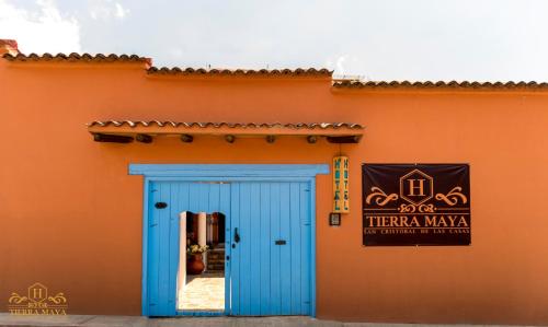 a blue door on the side of a orange building at Hotel Tierra Maya in San Cristóbal de Las Casas