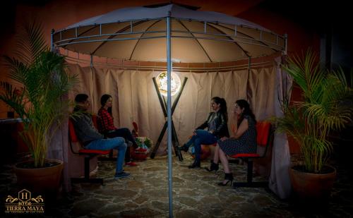 a group of people sitting under an umbrella at Hotel Tierra Maya in San Cristóbal de Las Casas