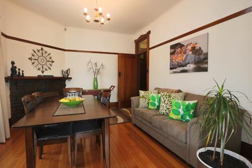 a living room with a couch and a table at Moonah Central Apartments in Hobart