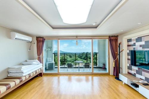 a bedroom with a bed and a large window at Jeju I've Hotel & Resort in Seogwipo
