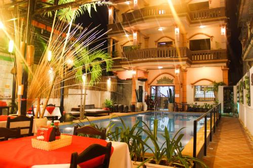 ein Hotel mit einem Pool in einem Gebäude in der Unterkunft Tropical Breeze in Siem Reap