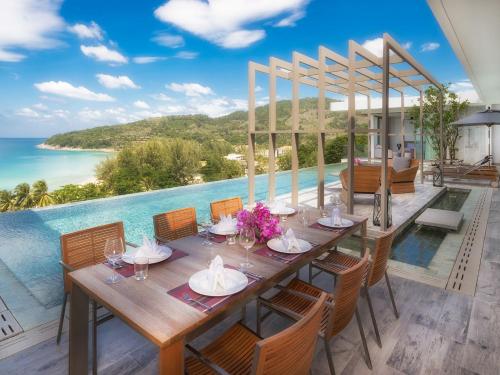 a dining table with a view of the ocean at Malaiwana Residences in Nai Thon Beach