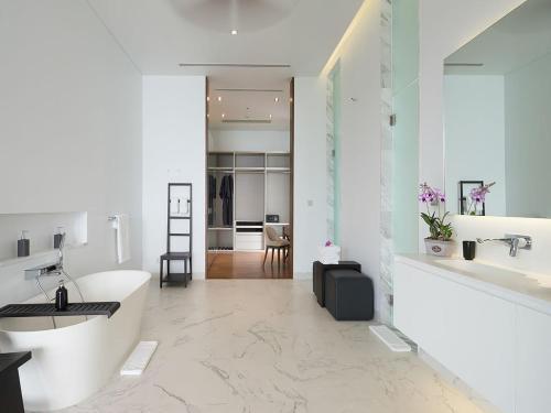 ein weißes Badezimmer mit einem Waschbecken und einem Schreibtisch in der Unterkunft Malaiwana Residences in Nai Thon Beach