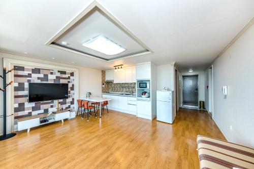 a large living room with a table and a kitchen at Jeju I've Hotel & Resort in Seogwipo
