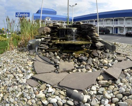 a water fountain on a rocky ground in front of a building at Superlodge Absecon/Atlantic City in Absecon