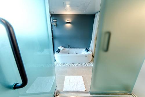 a view of a bathroom with a bath tub at Jeju I've Hotel & Resort in Seogwipo