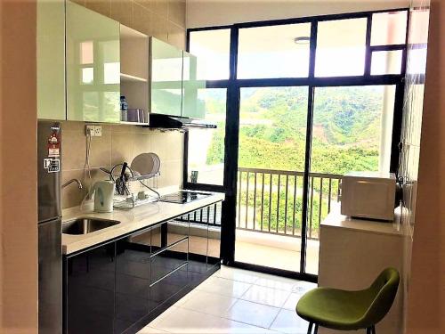 une cuisine avec un évier et une grande fenêtre dans l'établissement Sekata Apartment, à Cameron Highlands