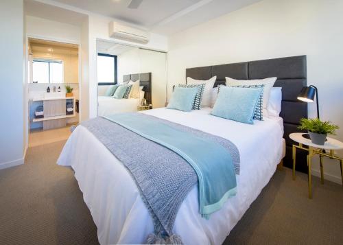 a large bedroom with a large bed with blue pillows at Alcyone Hotel Residences in Brisbane