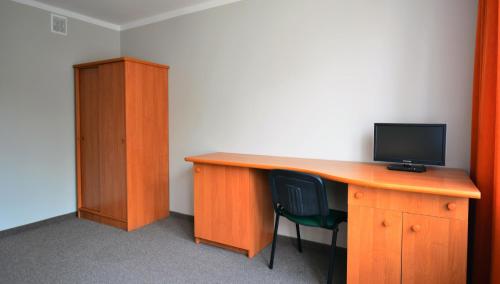an office with a wooden desk with a monitor and a chair at Hotel Felix in Kraków