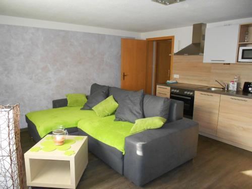 a living room with a couch with a green blanket at Crosta Brava in Großdubrau
