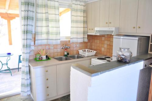 a kitchen with a sink and a stove at Phoenix Beachside Condos in Kokóni