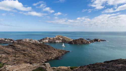 a sail boat in the water between two rocks at Hotel & Spa Terraza 4 Sup in Roses
