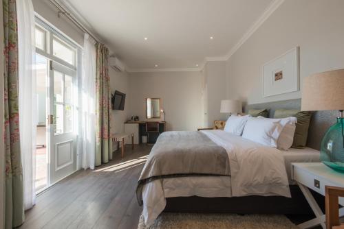 a bedroom with a bed and a large window at Waterstone Lodge in Somerset West