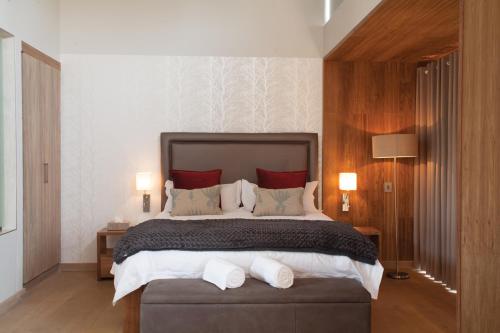 1 dormitorio con 1 cama grande con almohadas rojas en Menlyn Boutique Hotel, en Pretoria