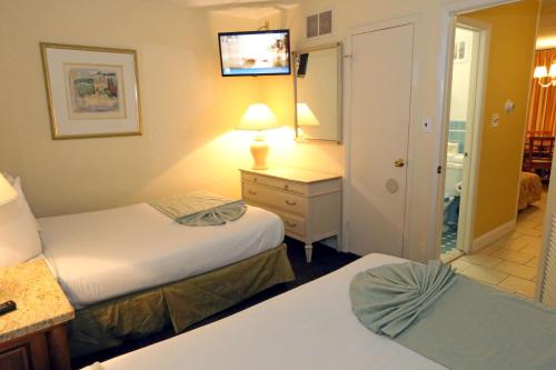 a hotel room with two beds and a mirror at Quebec Motel in Wildwood