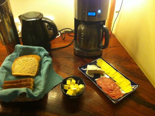 a table with a plate of food and a coffee maker at Windrose B&B in Denmark
