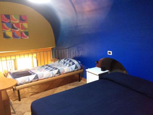 ナポリにあるCasa Coloreの青い壁の客室で、ベッド2台が備わります。