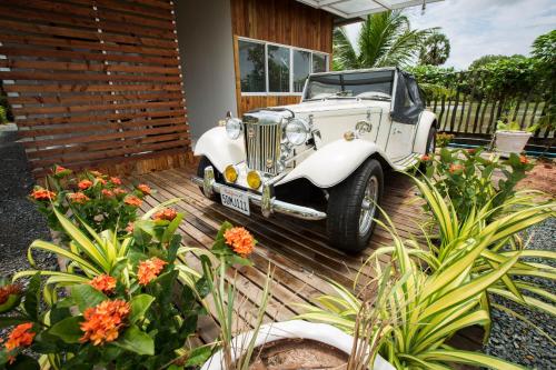 an old white car parked in front of a house at Kampot River Residence in Kampot