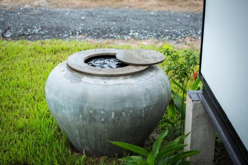 a large metal vase sitting in the grass at Kampot River Residence in Kampot