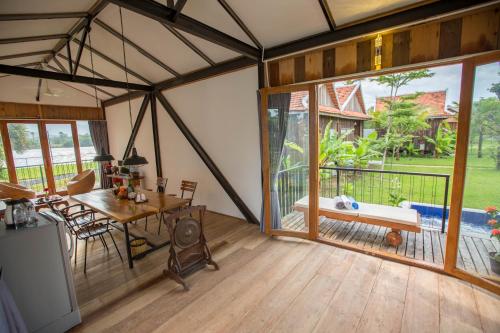 a room with a dining table and a large window at Kampot River Residence in Kampot