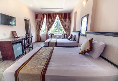 Cette chambre comprend deux lits et une télévision. dans l'établissement Song Huong Hue Hotel, à Hue