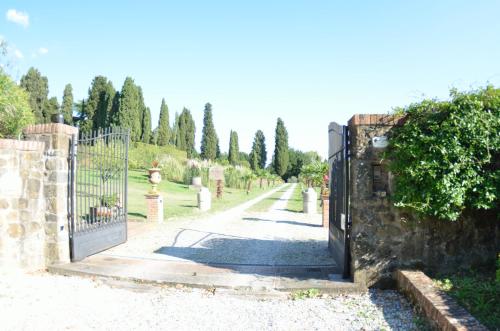 a gate in a stone wall with a driveway at Villa al Borghetto in Uzzano