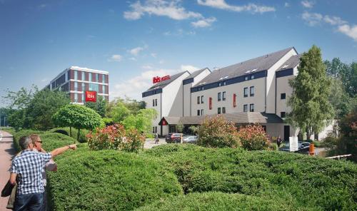 a man talking on a cell phone in front of a building at Ibis Brussels Erasmus in Brussels