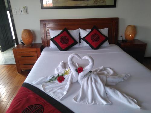 a bed with two swans made out of towels at Green CoCo HomeStay in Hoi An
