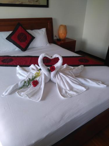 two swans wrapped in white towels on a bed at Green CoCo HomeStay in Hoi An