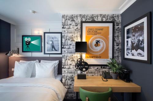 a bedroom with a bed and a desk and posters at The Highland House in Amsterdam