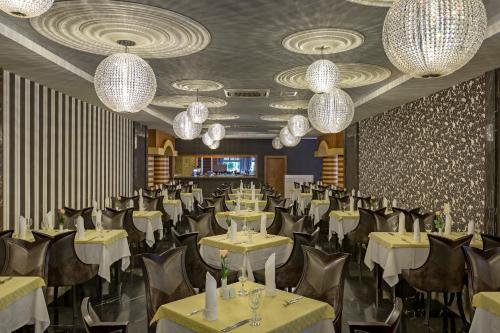 a banquet hall with tables and chairs and chandeliers at Royal Holiday Palace in Lara