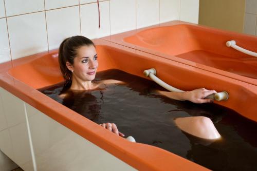 a woman is in a bath tub with water at Edward in Jelenia Góra