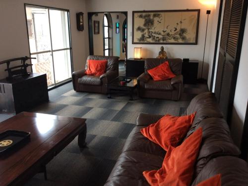 Sala de estar con 2 sofás y mesa de centro en Jonni`s Place, en Sakamoto