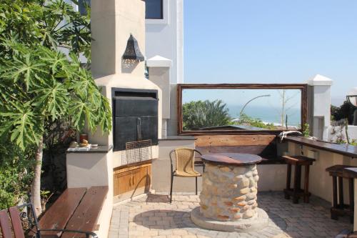 a patio with a grill and a table and a bench at JBay Surf View @ Point in Jeffreys Bay