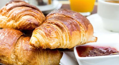 un gruppo di croissant su un piatto con una bevanda di Castroboleto Village a Nova Siri Marina