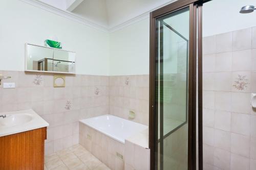 a bathroom with a shower and a sink at Byron Bay Accom Marvel St Byron Bay in Byron Bay