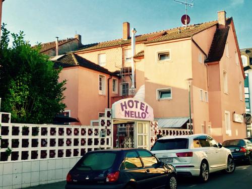 un par de autos estacionados frente a un hotel Meloni en Hotel Nello, en Offenbach