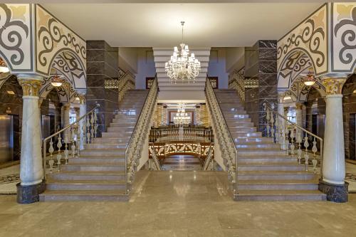 a set of stairs in a building with a chandelier at Royal Holiday Palace in Lara