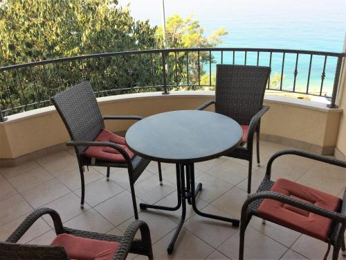 a table and chairs on a balcony with the ocean at Apartments Nevenka i Josko in Tučepi