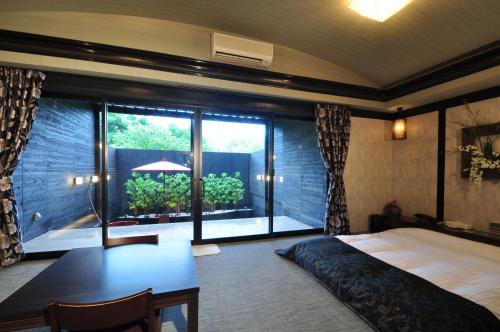 1 dormitorio con cama, escritorio y ventana en LaLa Resort (Adult Only) en Kobe