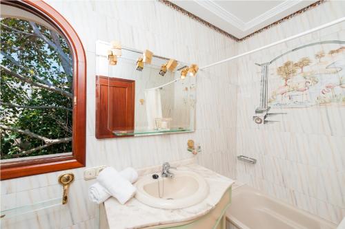 a bathroom with a sink and a mirror and a tub at Ullàs in Alcudia