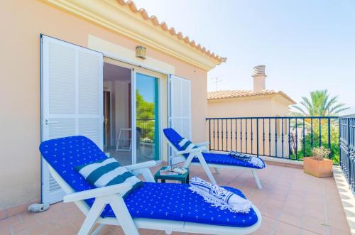 a pair of blue chairs sitting on a balcony at Bugambilia in Sa Ràpita
