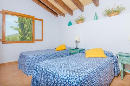 two beds in a white room with a window at Son Sabater (Es Moli Nou) in Sa Pobla
