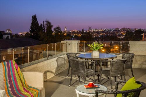 a patio with a table and chairs on a balcony at Rafael Residence Boutique in Jerusalem