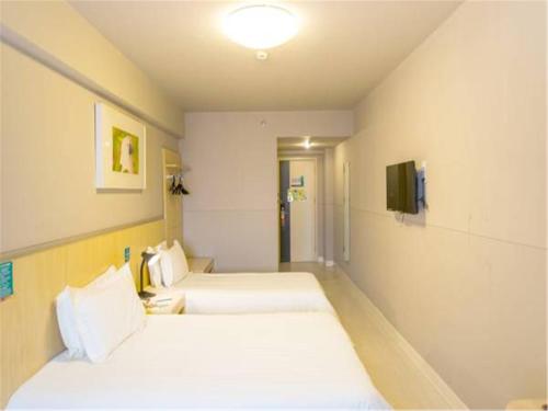Ein Bett oder Betten in einem Zimmer der Unterkunft Jinjiang Inn Central Qingdao Hangzhou Road