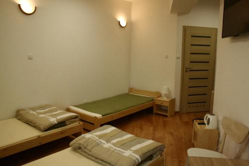 a small room with two beds and a closet at Pokoje Gościnne Marusa in Szczytno