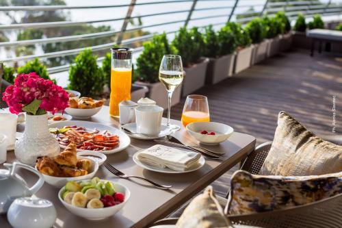 a table with food and glasses of wine on a balcony at Alàbriga Hotel GL in S'Agaro