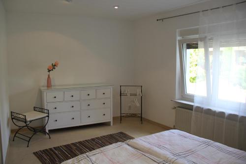 a bedroom with a bed and a dresser and a window at M-Apart Apartment in Lauchhammer